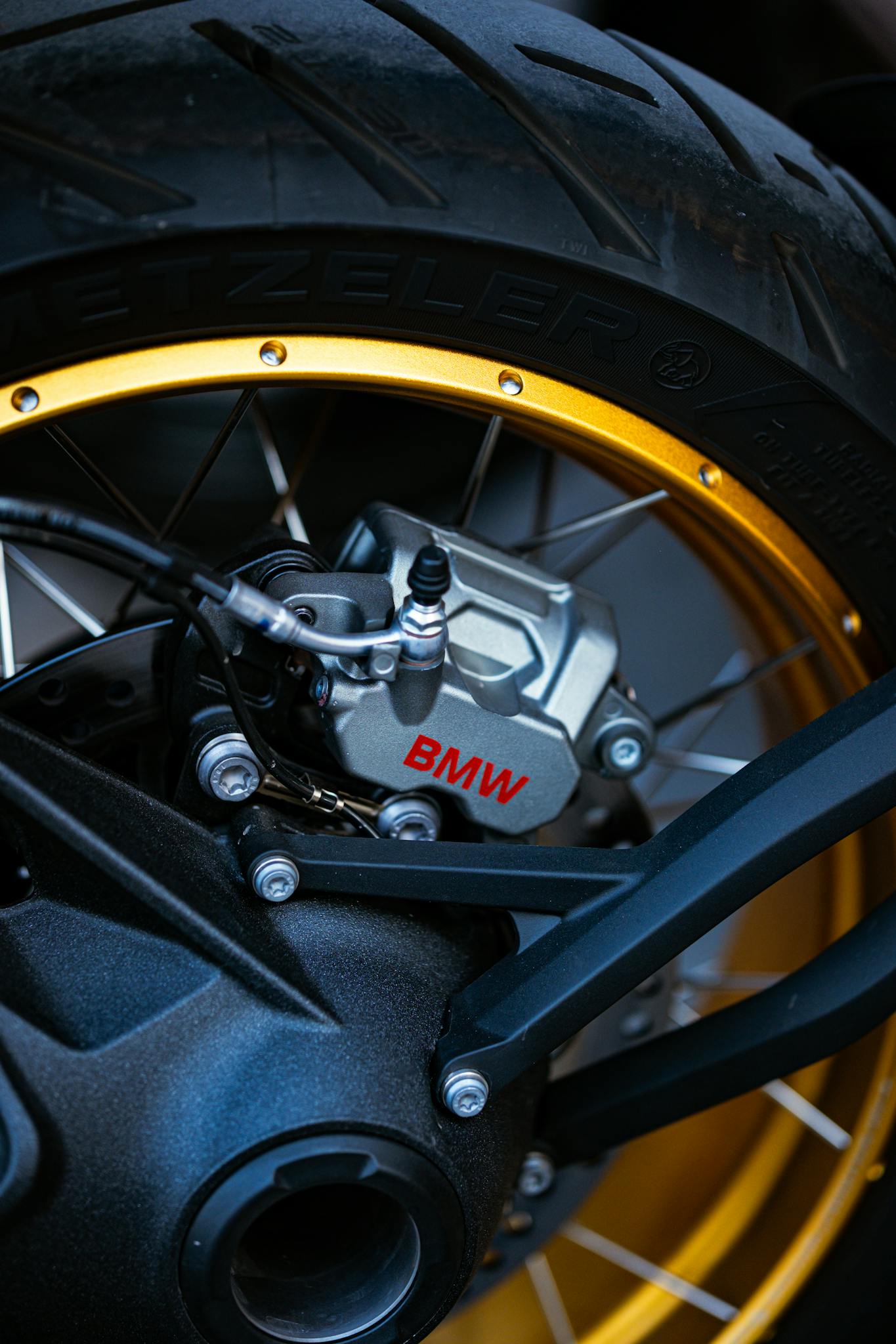 Detailed view of a BMW motorcycle wheel showcasing the brake components and golden rim.