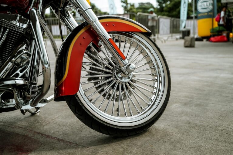 Detailed view of a custom chrome motorcycle wheel with vibrant red fender outdoors in Quezon City.