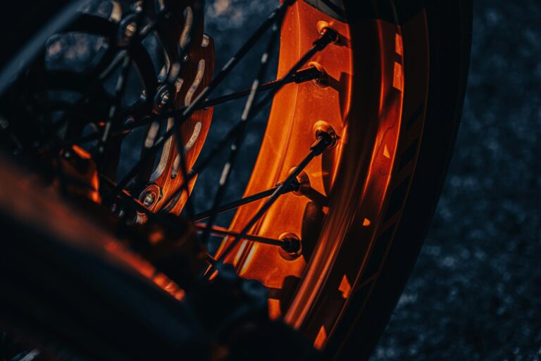 Detailed view of a motorcycle wheel rim and spokes with dramatic lighting.
