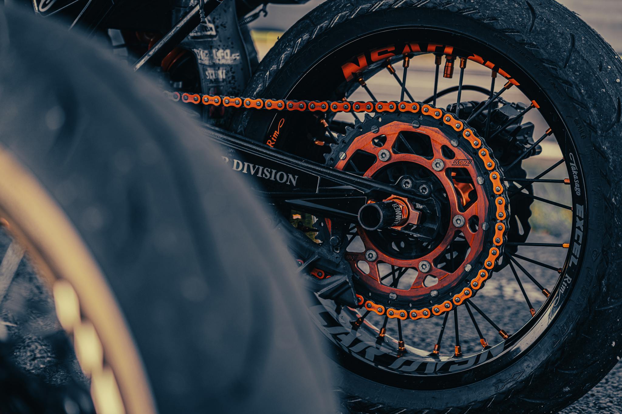 Detailed view of a motorcycle's rear wheel chain and sprocket highlighting its design and structure.